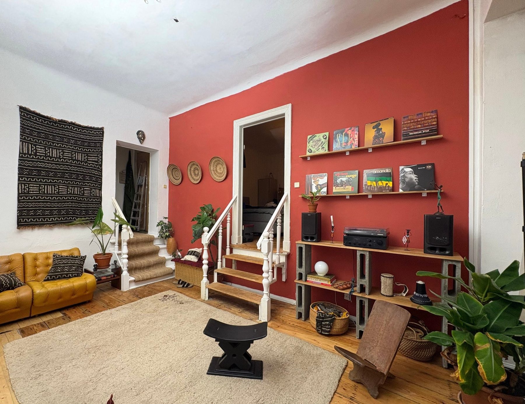 The finished Full Circle living room with the terracotta wall, records, plants and woven baskets